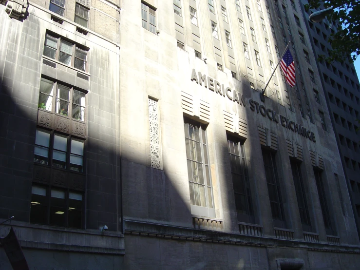 a grey building with windows and a flag hanging on the side