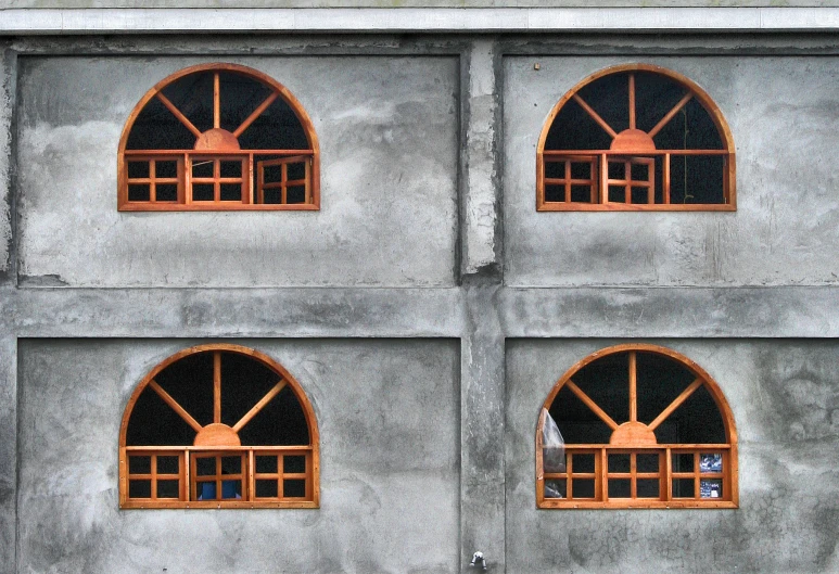 four open windows on a wall that are attached to the side of a building