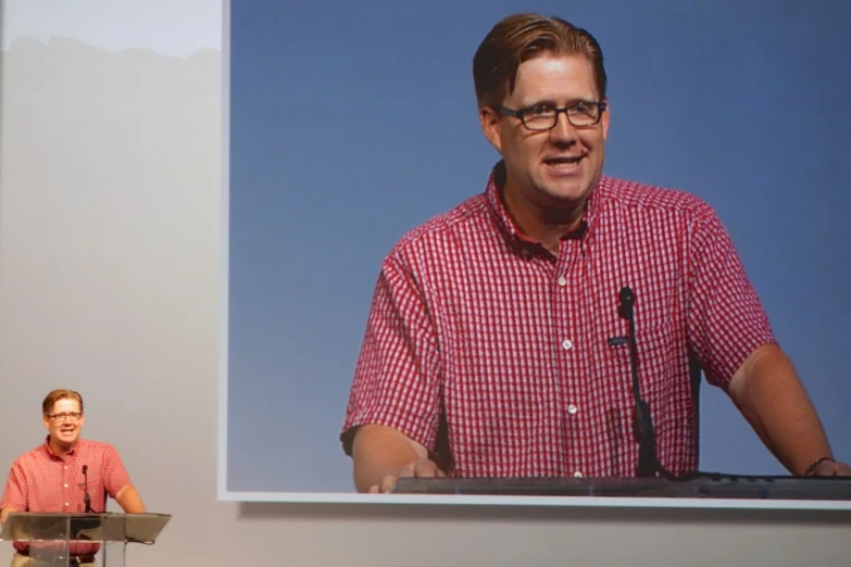 a man in a red shirt giving a presentation