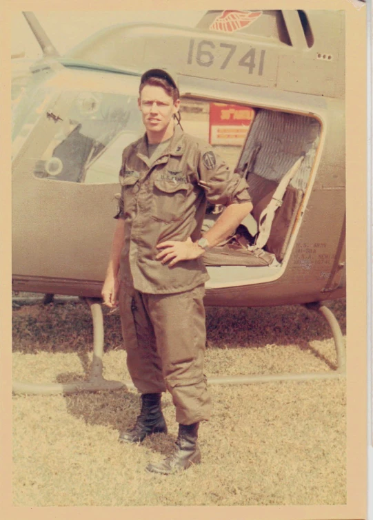 a man stands next to a helicopter