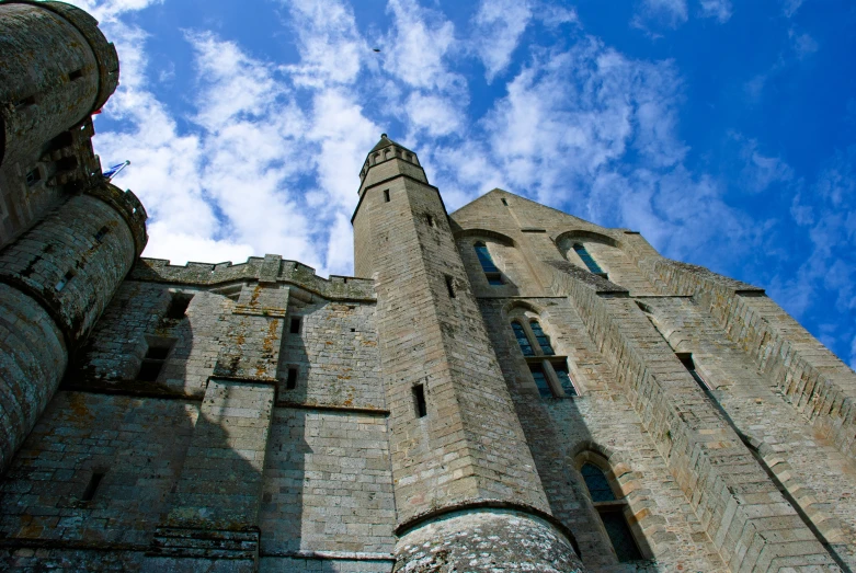 a tall building with a clock and tall towers under the blue sky