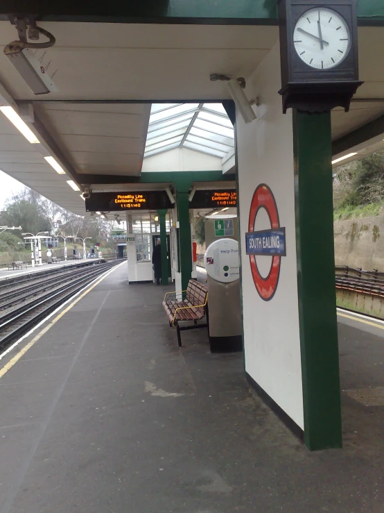 a train station with a bench next to a clock