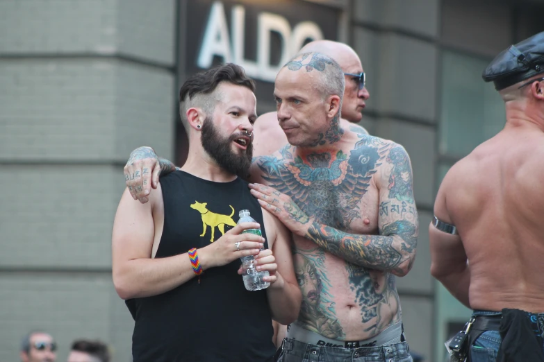 two men with tattoos are standing close together