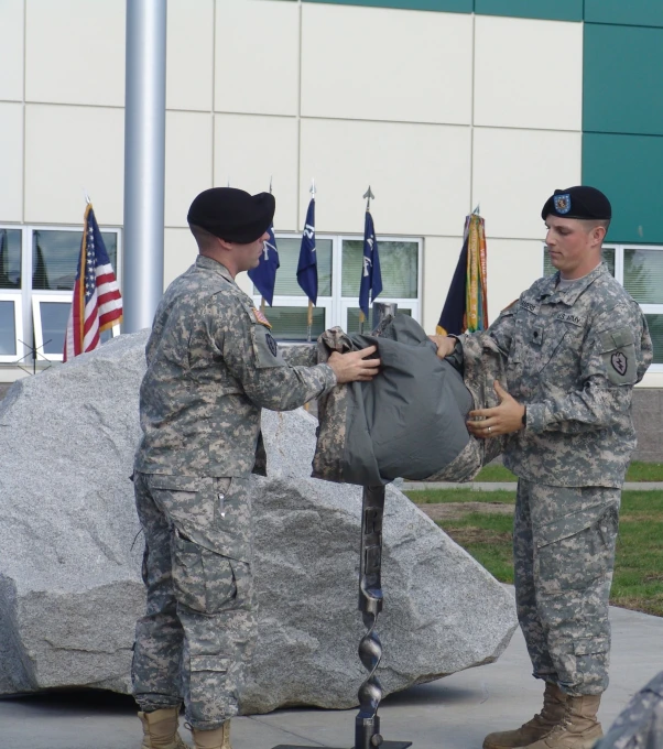 two soldiers are taking a rock and putting them into another one