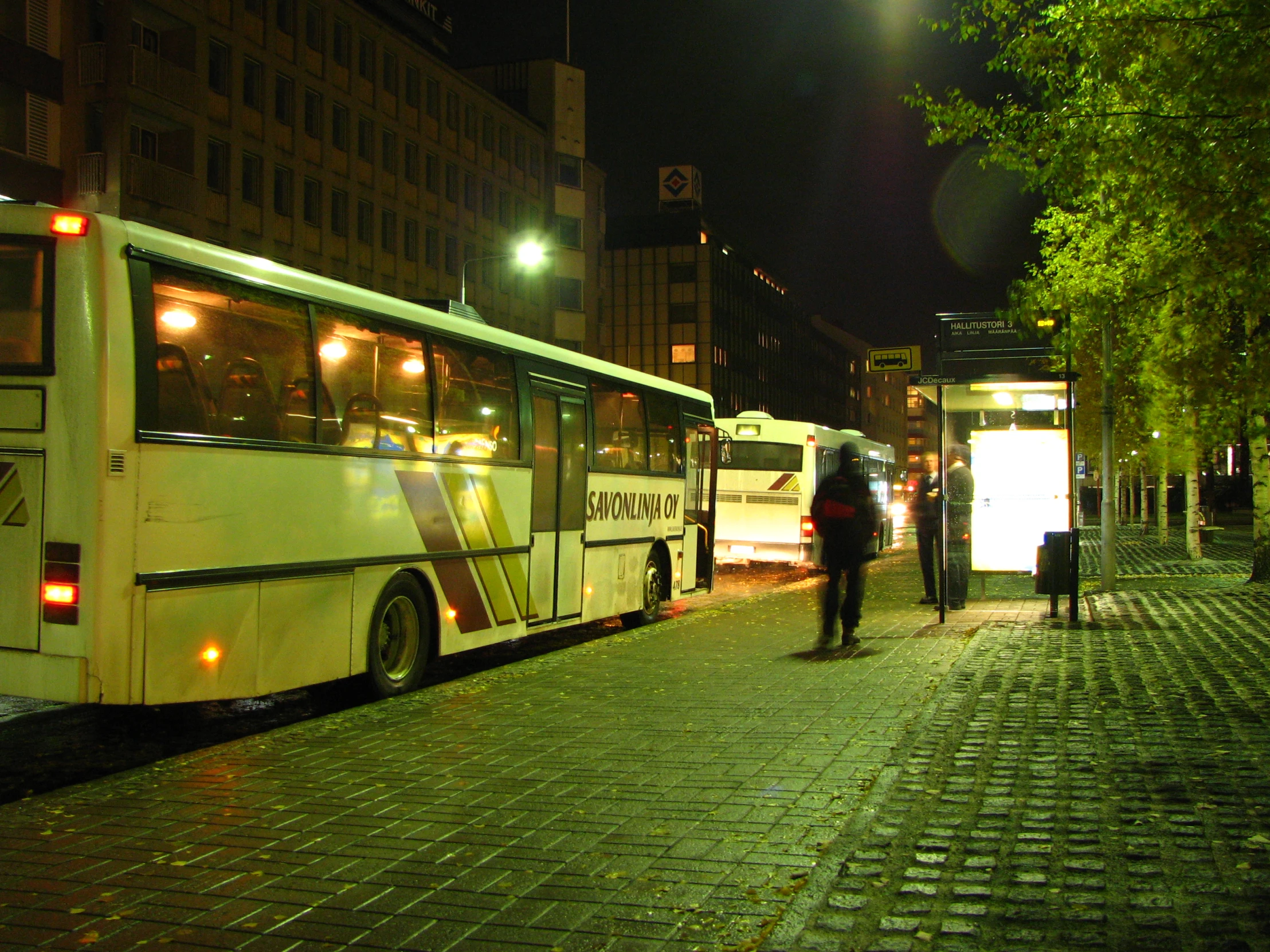 two buses sitting in front of a tall building