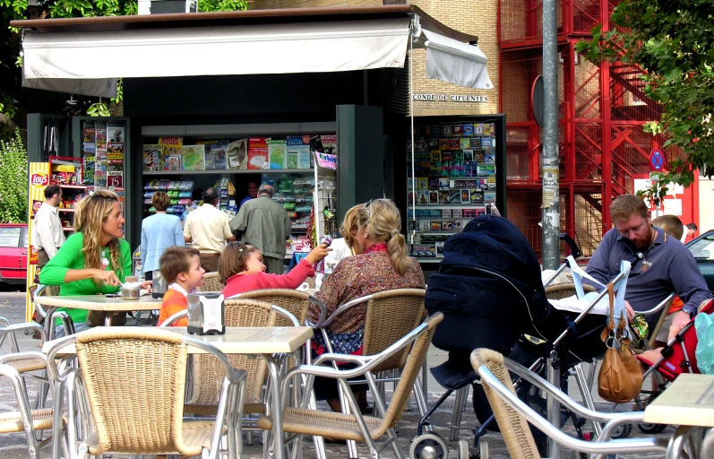 many people are sitting outside of a business