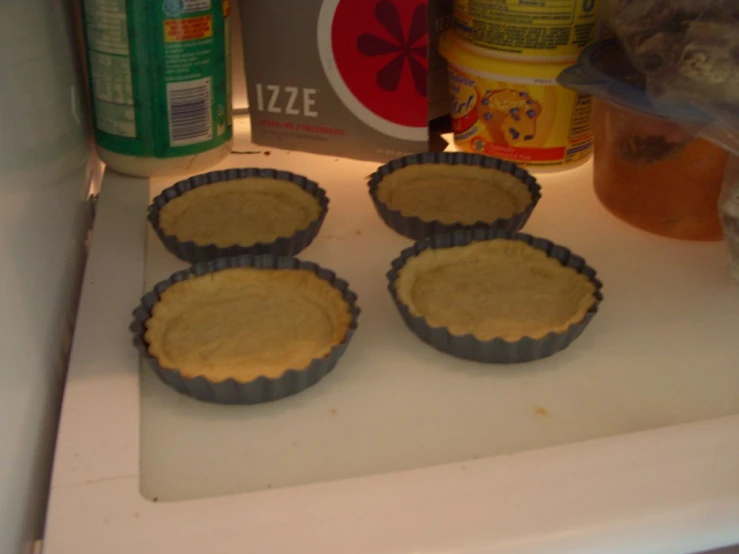 four pans of food sit on a surface