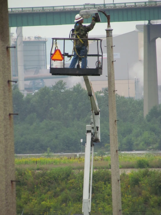 a man working on a utility box on the side of a highway