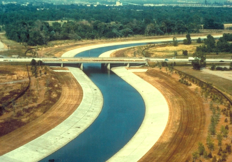 a blue river flowing between two roads