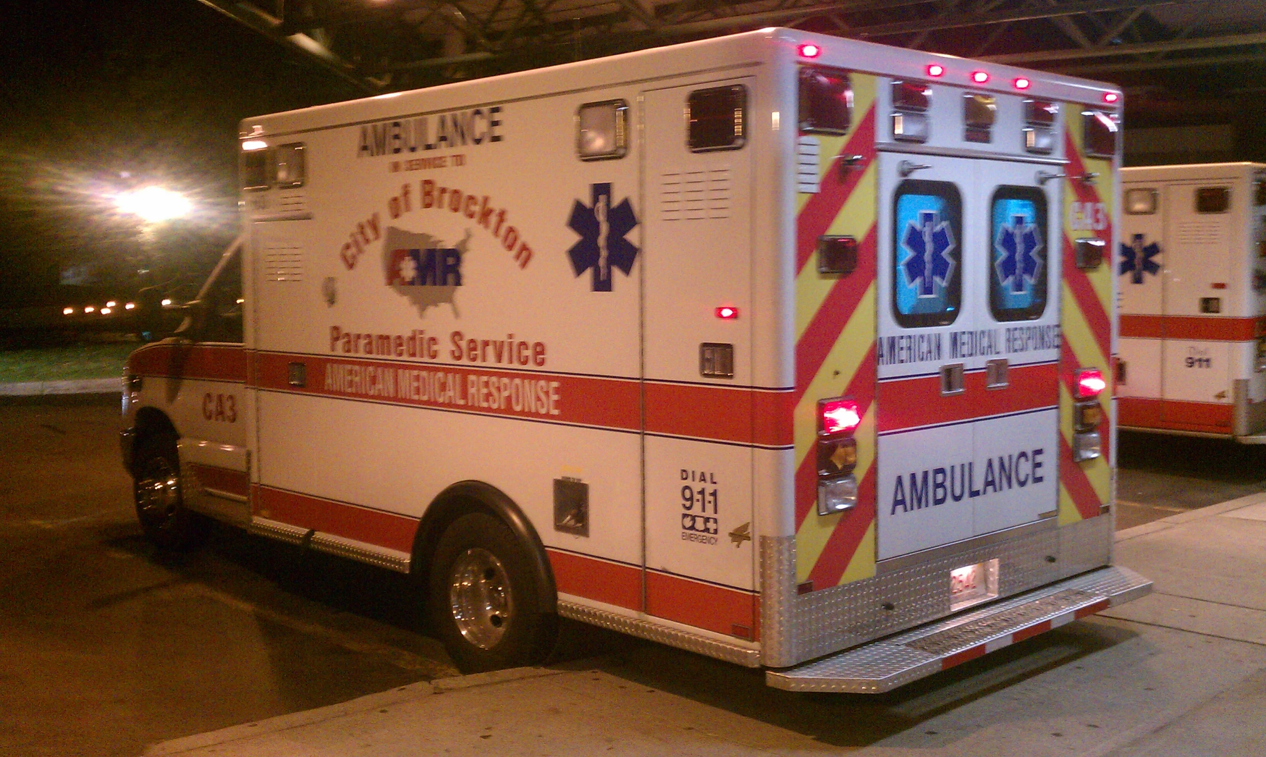 an ambulance parked next to another ambulance outside a building