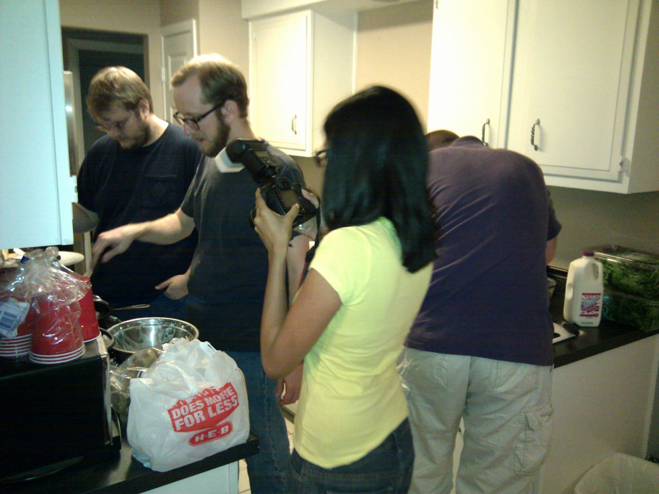 there are some people standing in the kitchen together