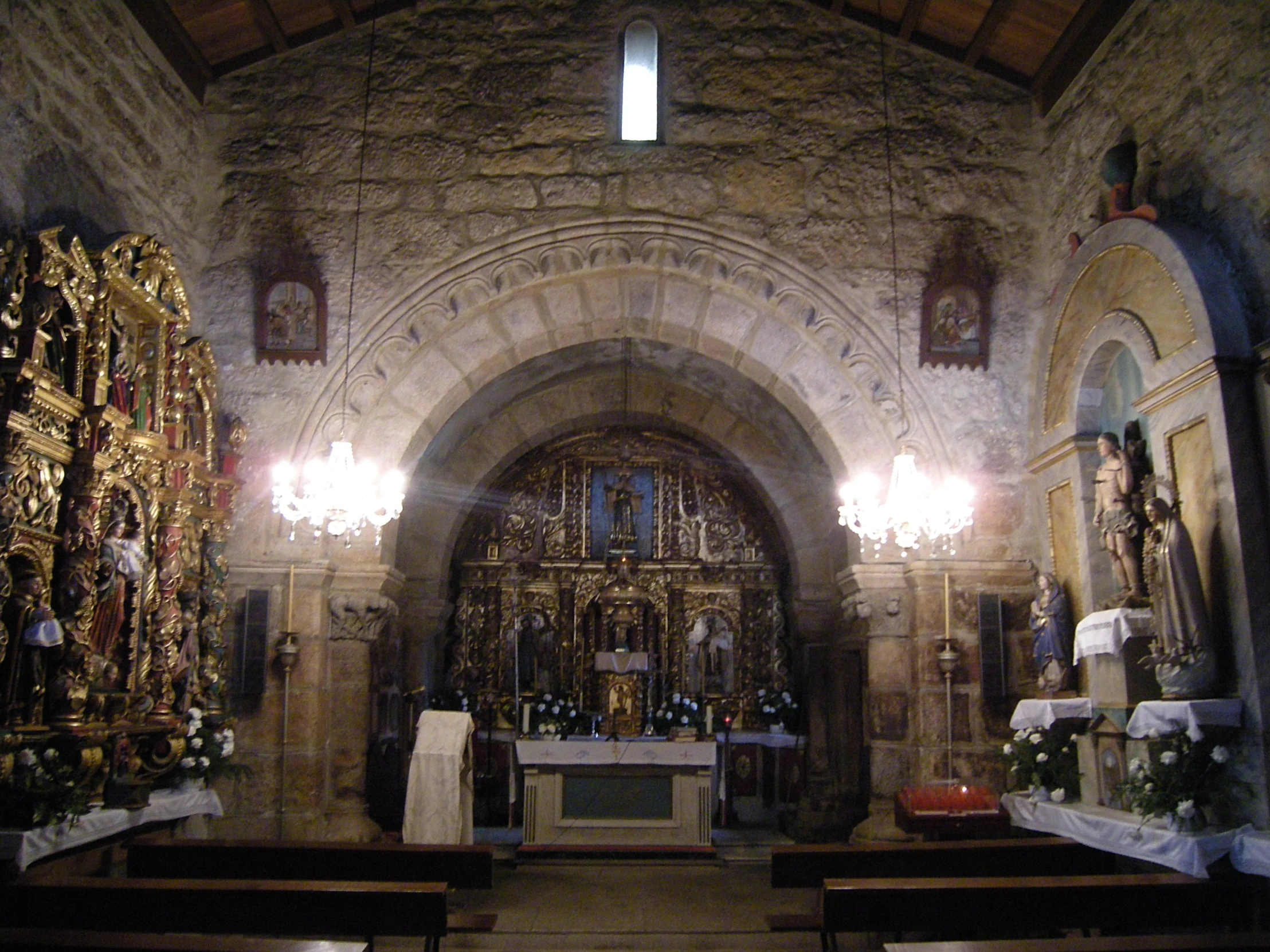 an arched church entrance with statues and candles