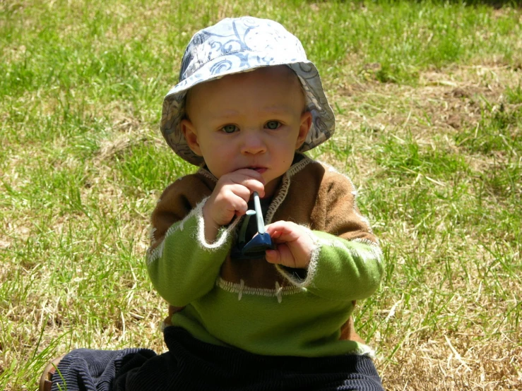 a small child wearing a hat holding a remote