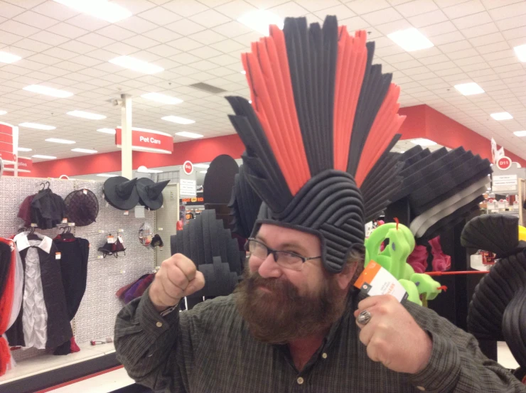 man wearing a plastic headdress and playing with a toothbrush in a toy store