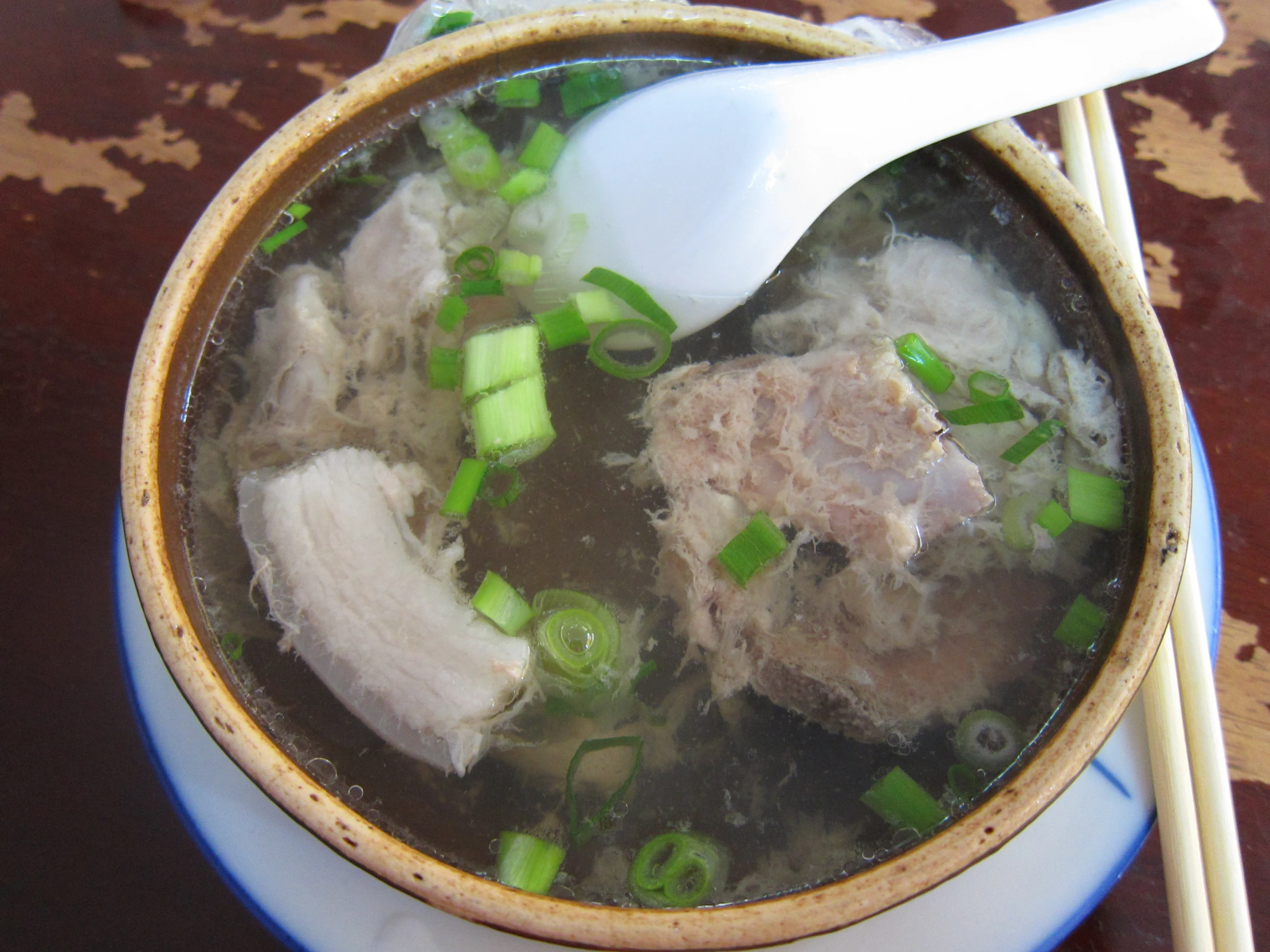 a bowl filled with meat and vegetables on top of a table