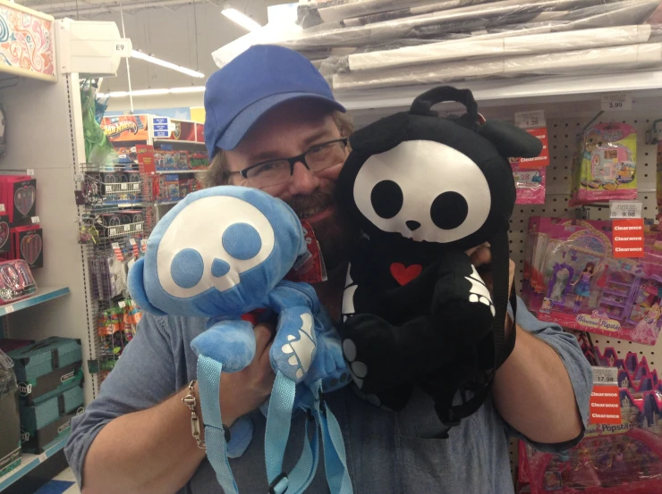 a man is holding two stuffed animals inside of the store