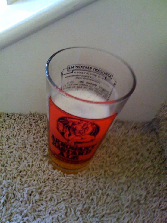 a glass filled with liquid on top of a floor