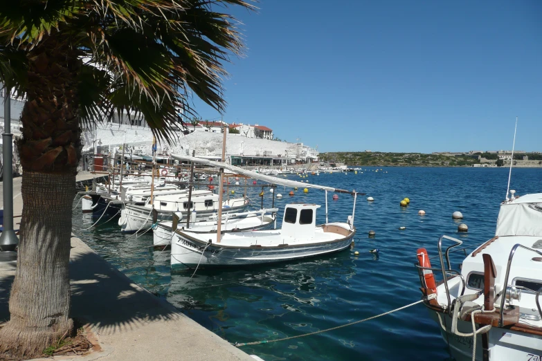 three boats sit in the water next to a dock