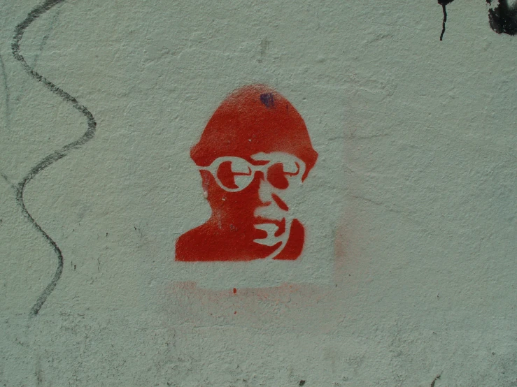 a wall with a red sticker of a man wearing glasses