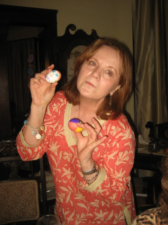 a woman holding a small object with two fingers