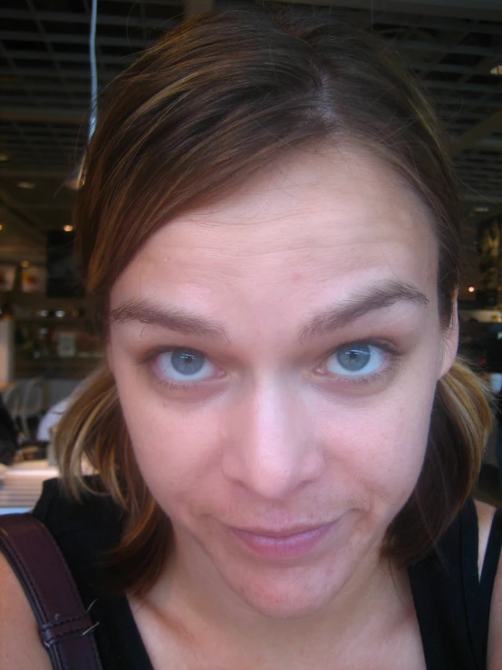 a woman with light blue eyes looks into the camera