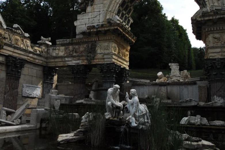 three statues next to a pond in a park