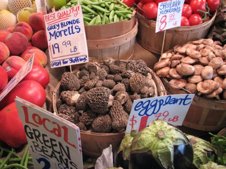 various baskets of fruit and vegetables displayed at an outdoor market