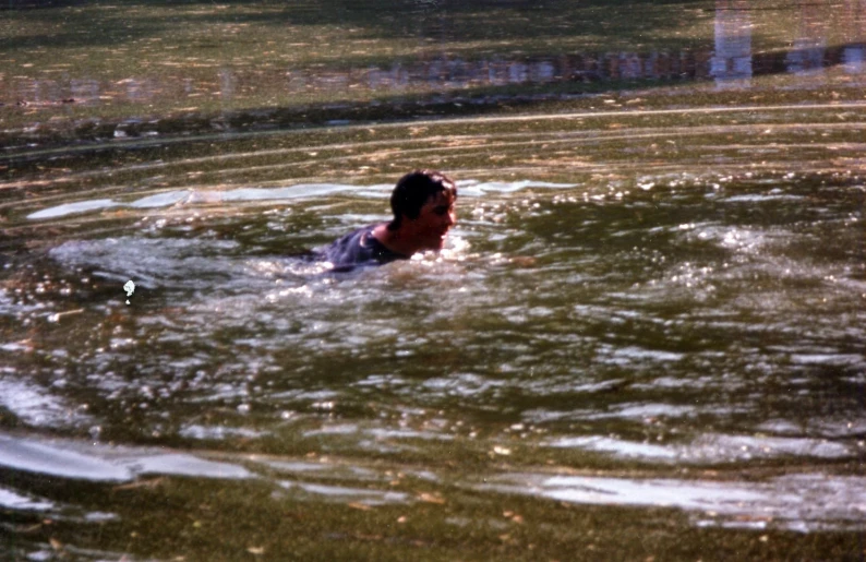 a person swimming in a lake in the water