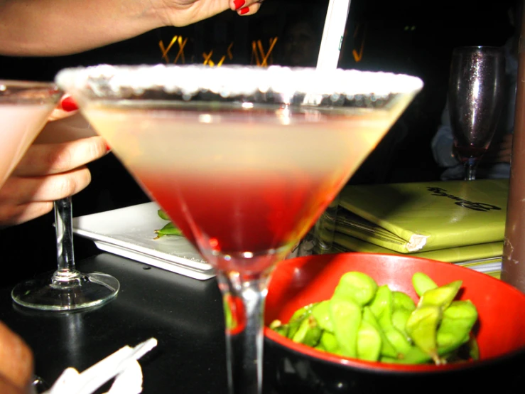 a person pours liquid into a martini