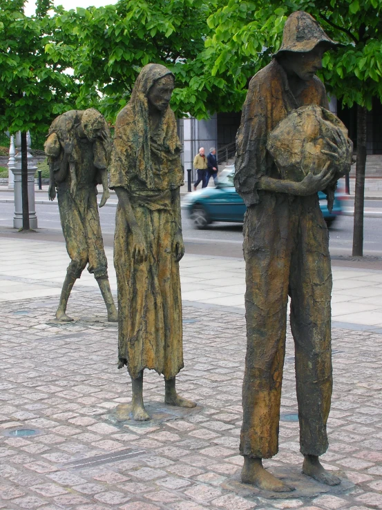 three statues of people standing next to each other