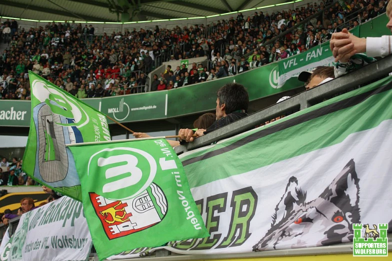 a fan is holding up a green and white flag