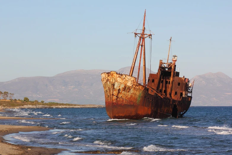 an old rusty ship in the middle of a body of water