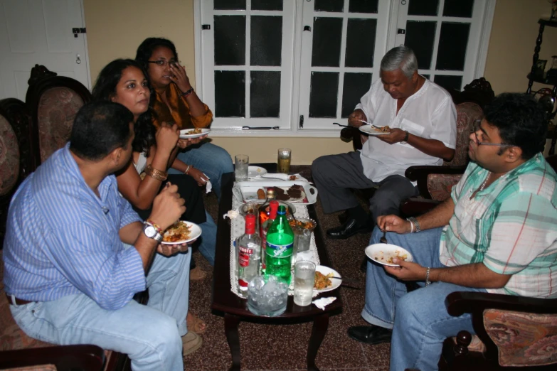 a group of people sitting around eating dinner