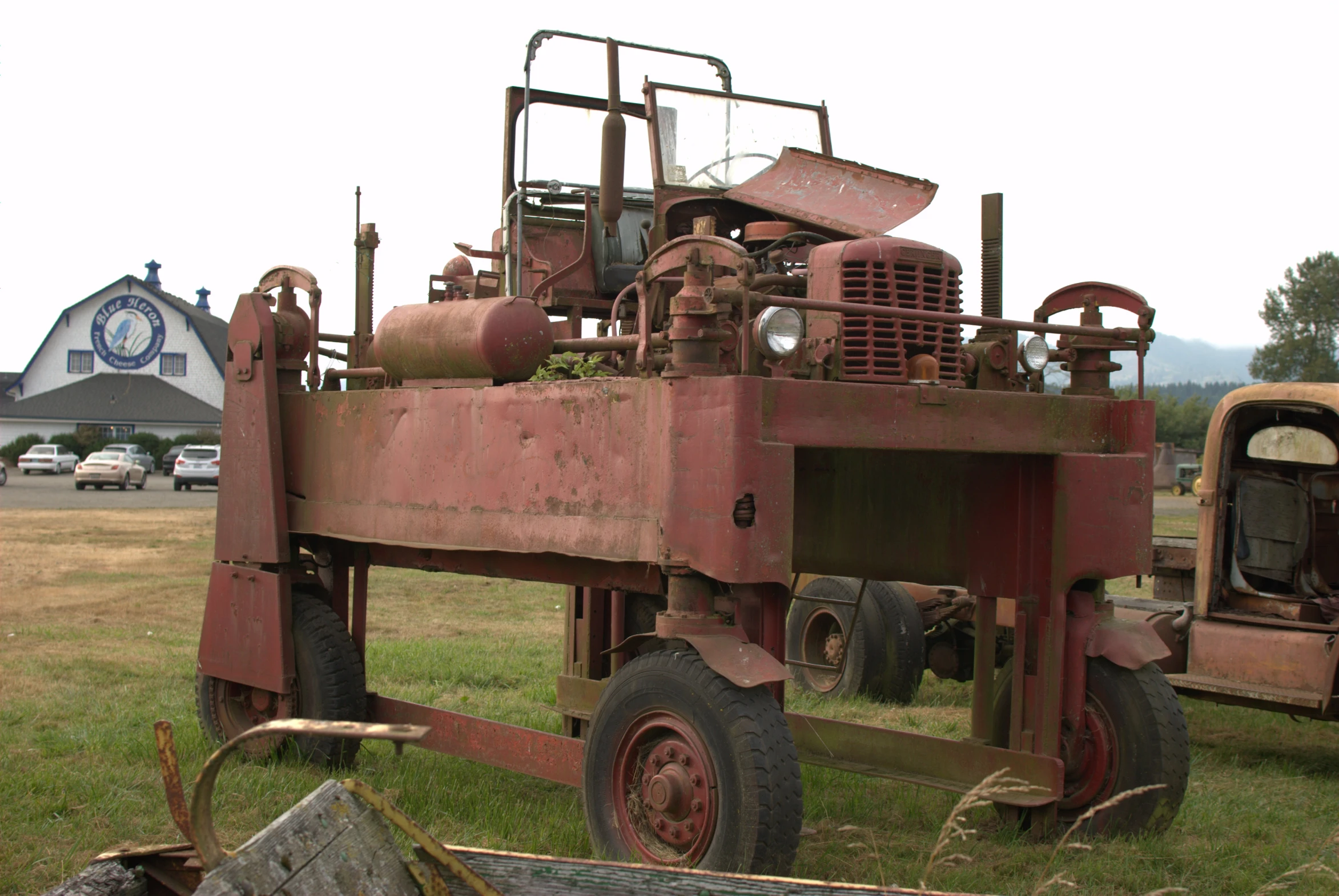 a rusted out tractor sitting in the grass