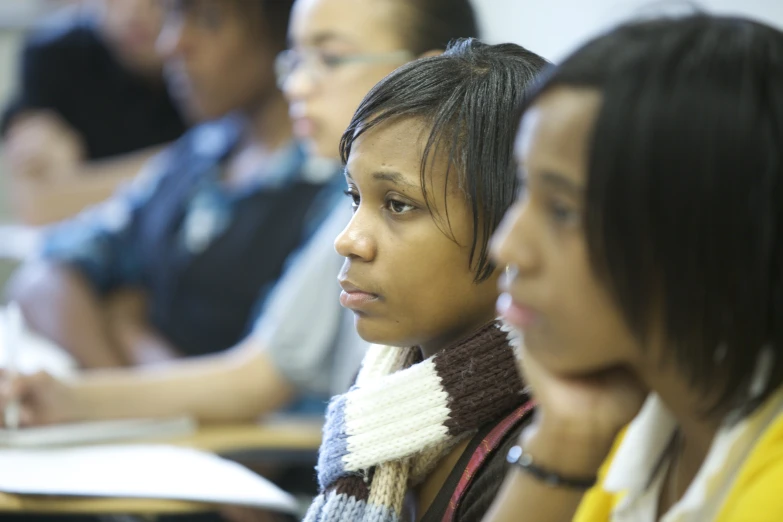 two girls looking off into distance with other students