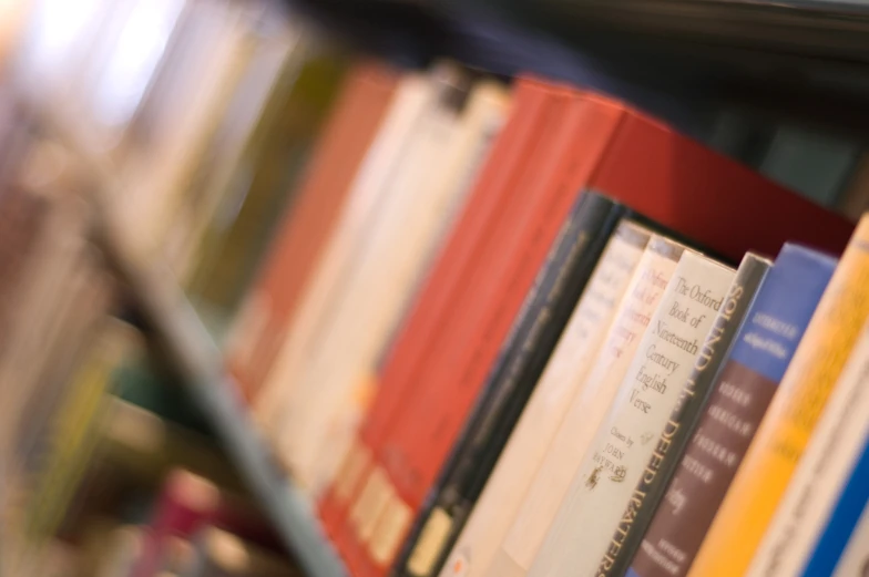 a book shelf with various books and two empty glasses