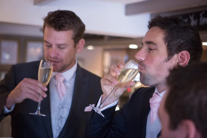 two men dressed up drinking champagne together