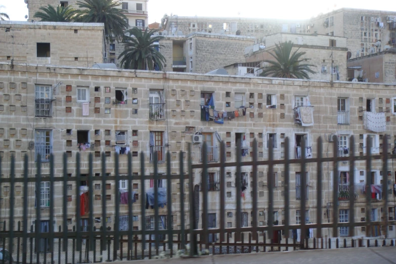 an old building with a number of small windows with drying clothes hanging outside the window