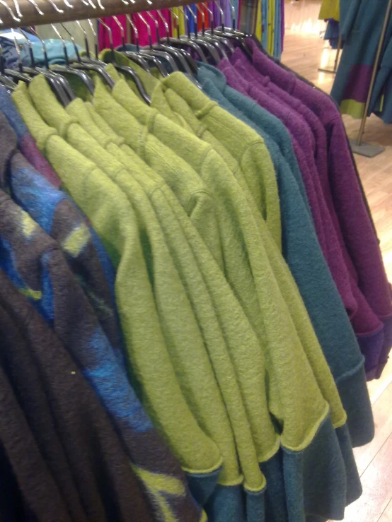 a bunch of sweaters that are hanging up