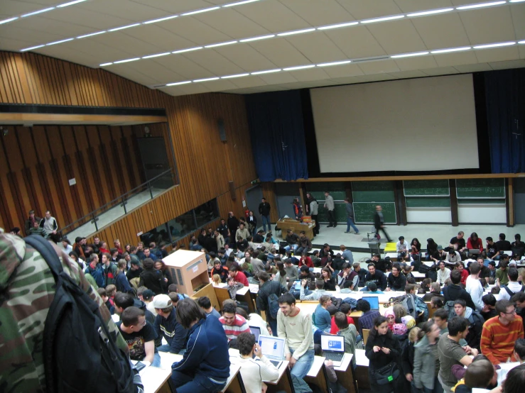 an auditorium full of students sitting at tables
