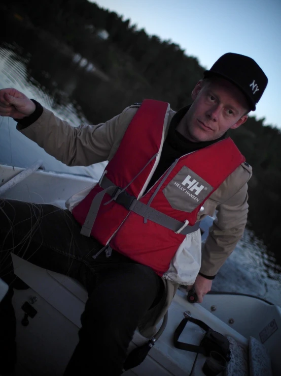 a man with a life vest and hat sitting on a boat