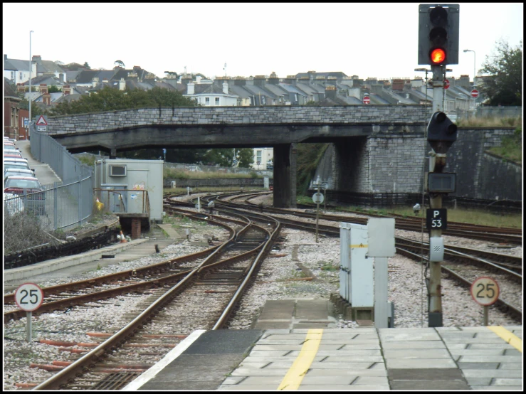 train tracks under a bridge and a street