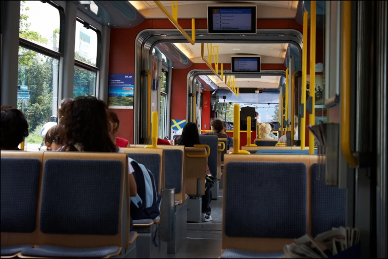 people riding on a transit bus with empty seats