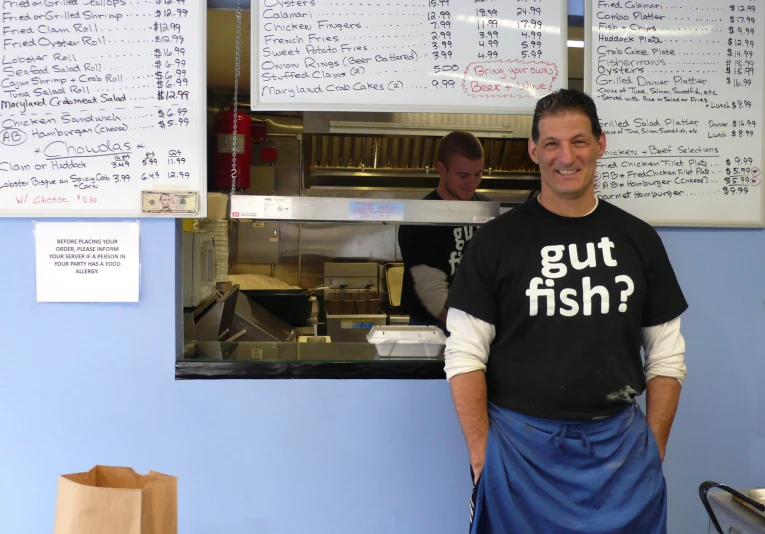 a chef is leaning against the counter with his apron on