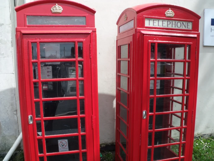 a couple of red telephone booths sitting next to each other