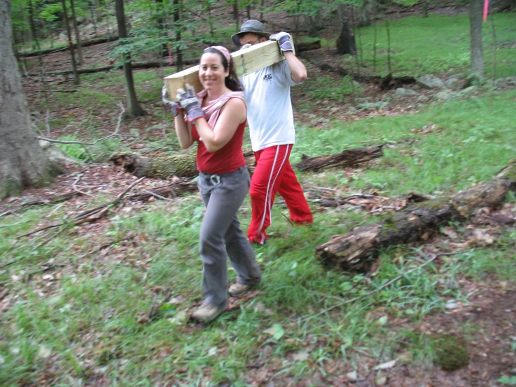 two people with sports equipment standing next to each other in the woods