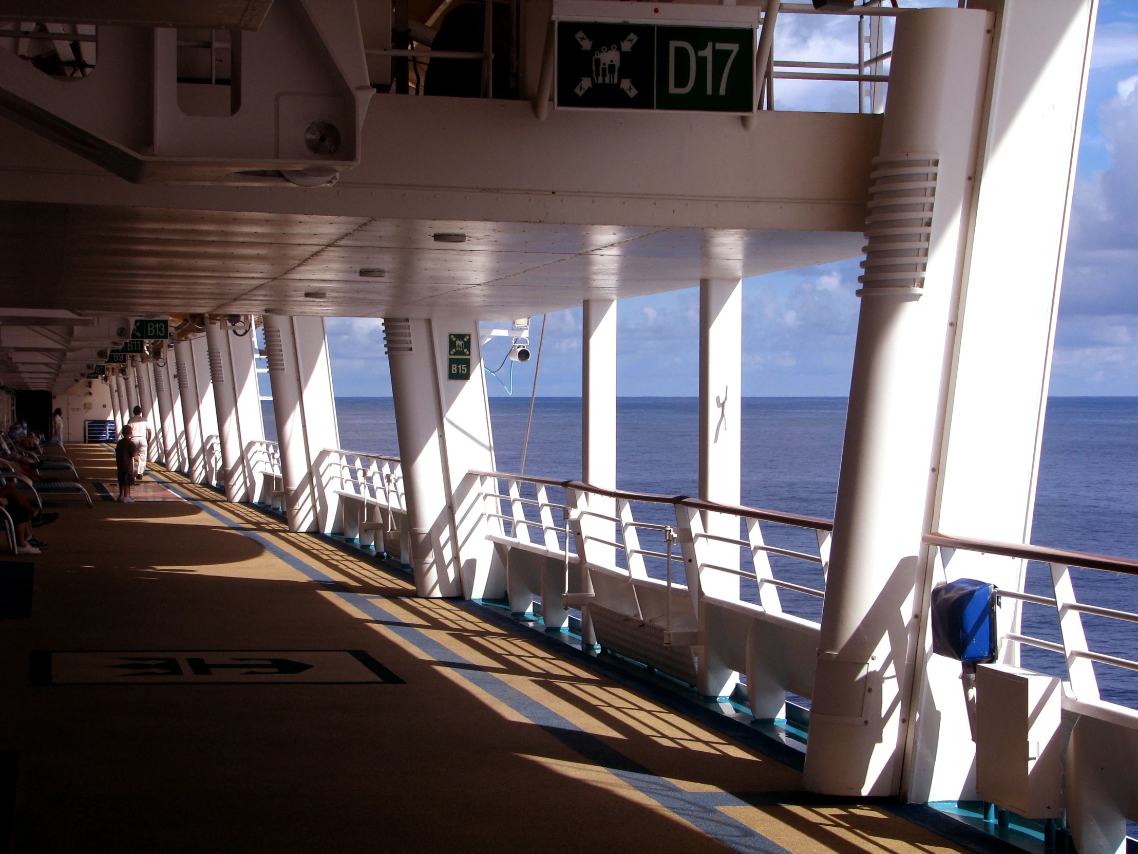 long deck area on an ocean liner with benches and signs