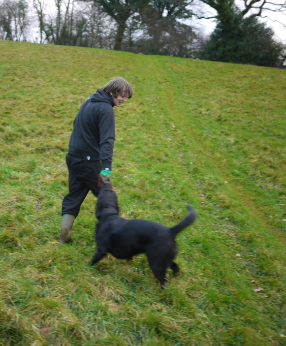 a man and a dog on a grassy hill