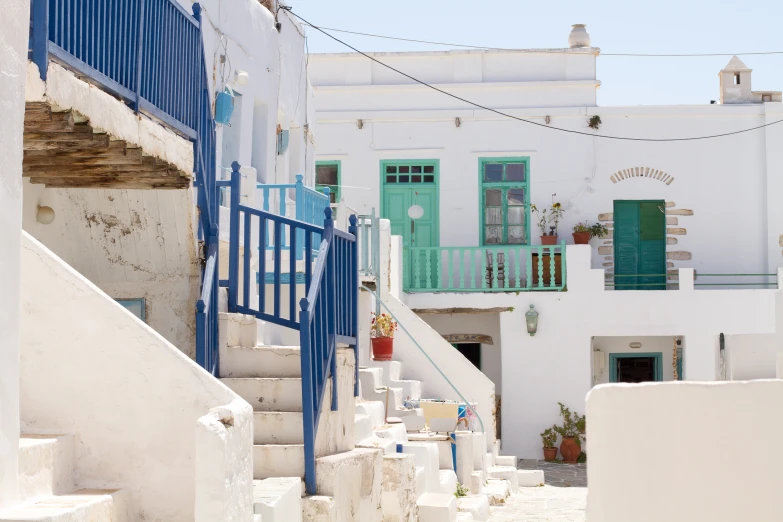 a set of stairs with blue railings leading up the street