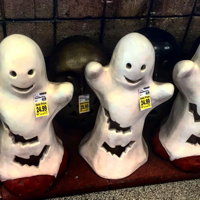 three creepy figurines are displayed in front of a wall